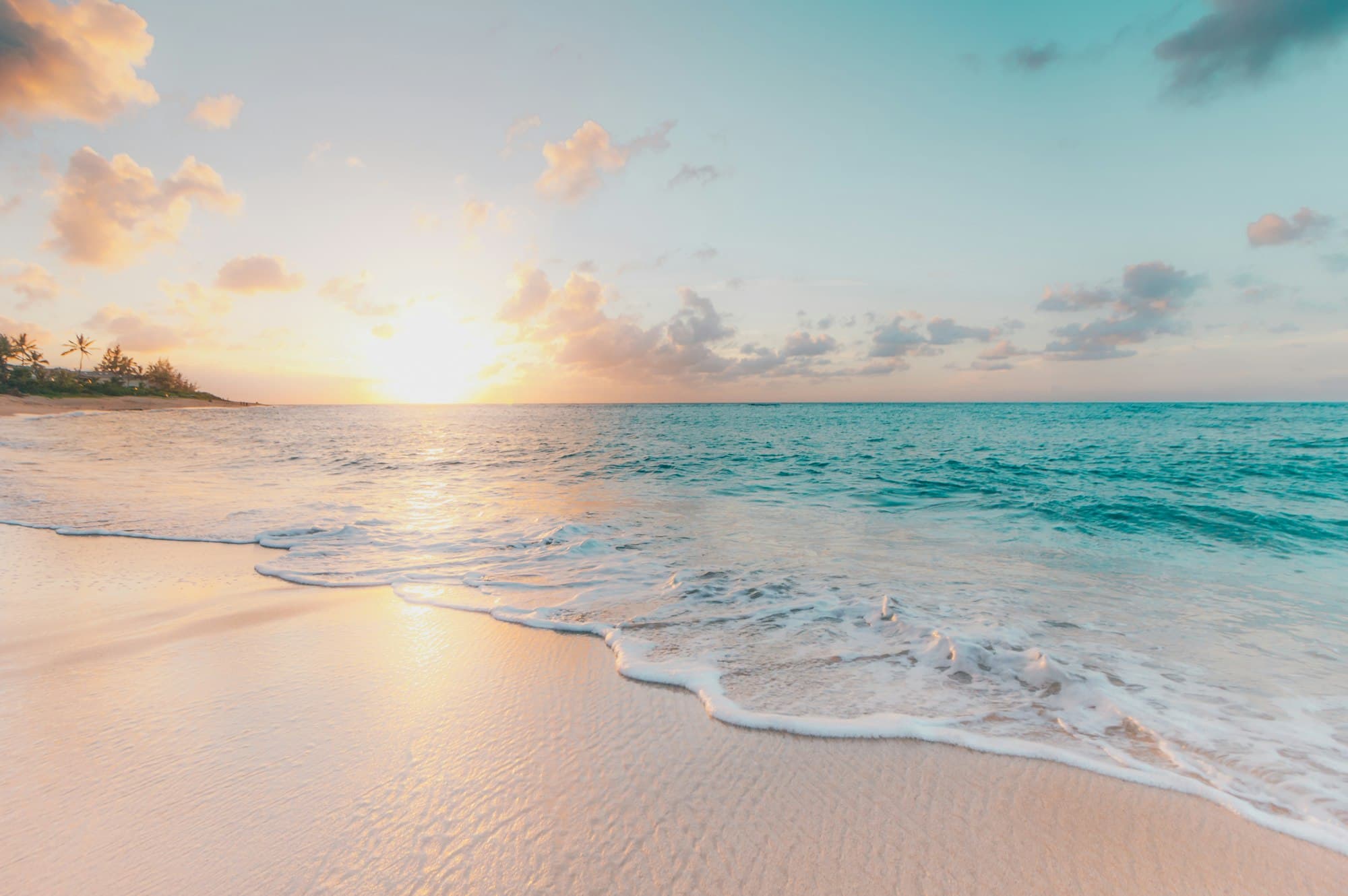 A quiet stretch of turquoise coastline at golden hour